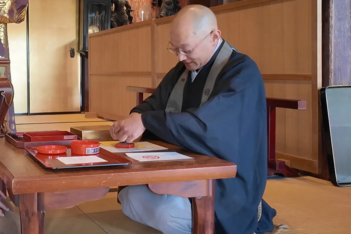 The priest stamps the Sanpo-in seal