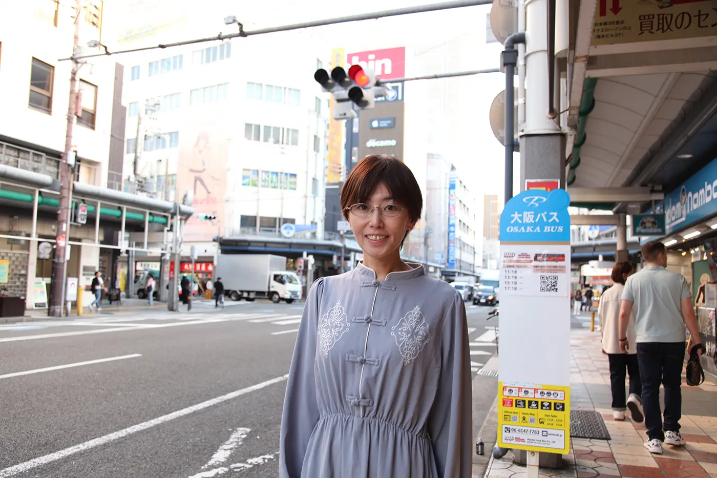 オオゴシトモエさんが街中で立っている様子