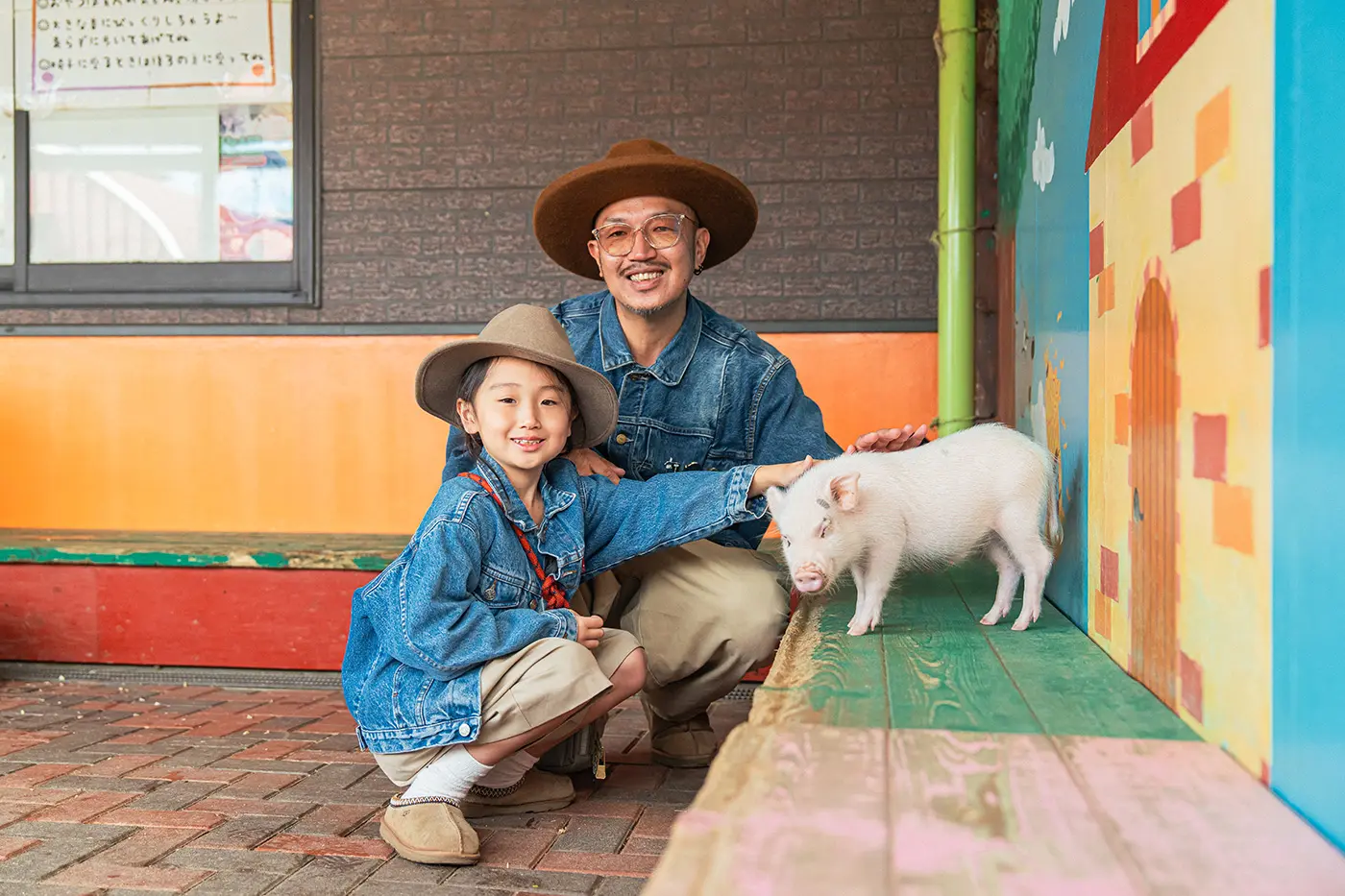 Parents and children interacting with baby mini pigs