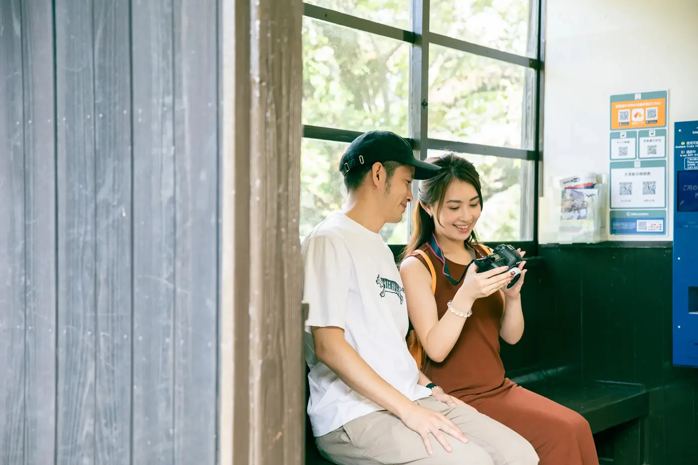 Two people checking photos in the waiting room at the station