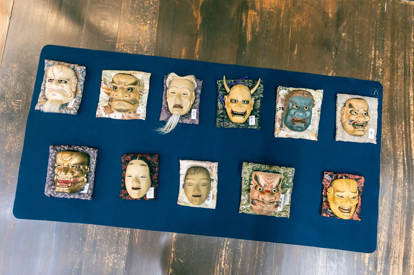 Numerous Noh masks lined up on the floor