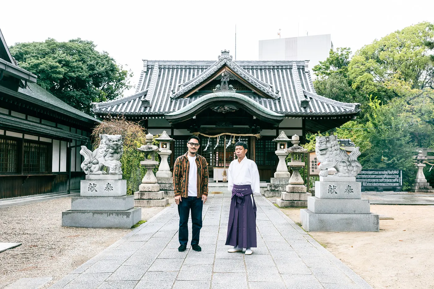 Guide and chief priest in front of the shrine's worship hall