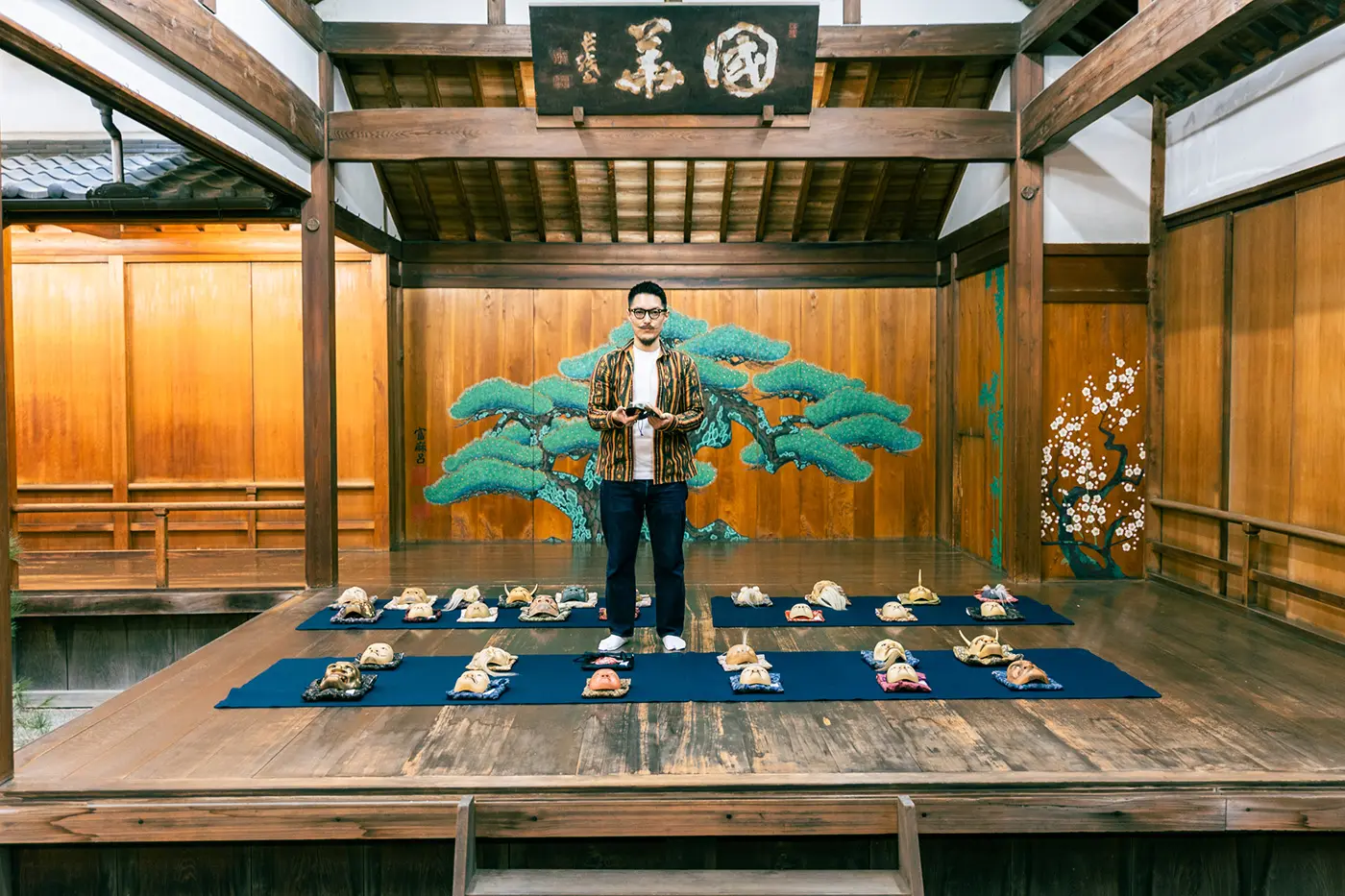 Kurimoto holding a Noh mask on the Noh stage