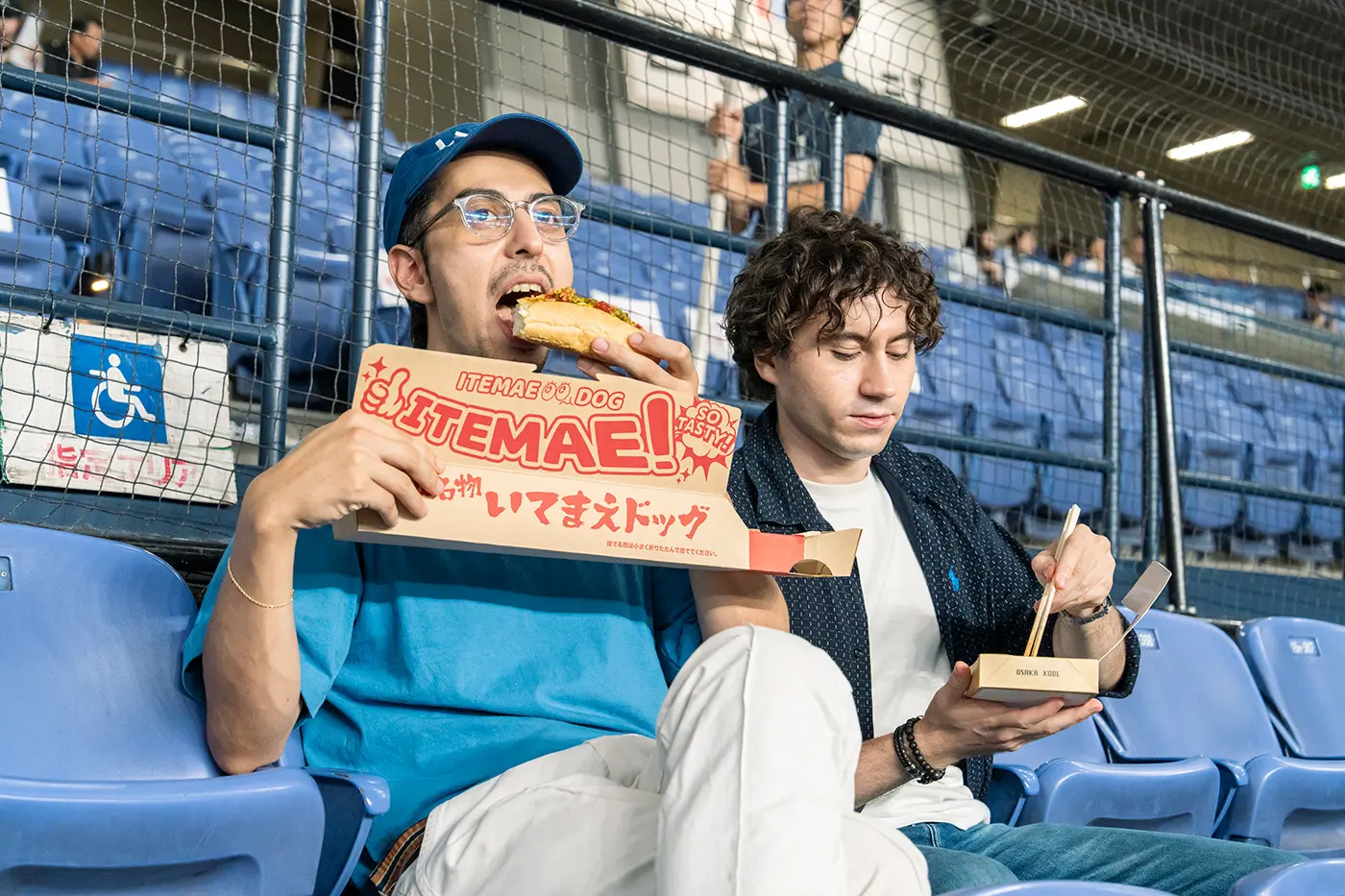 Enzo and Jason enjoying stadium food while watching the game