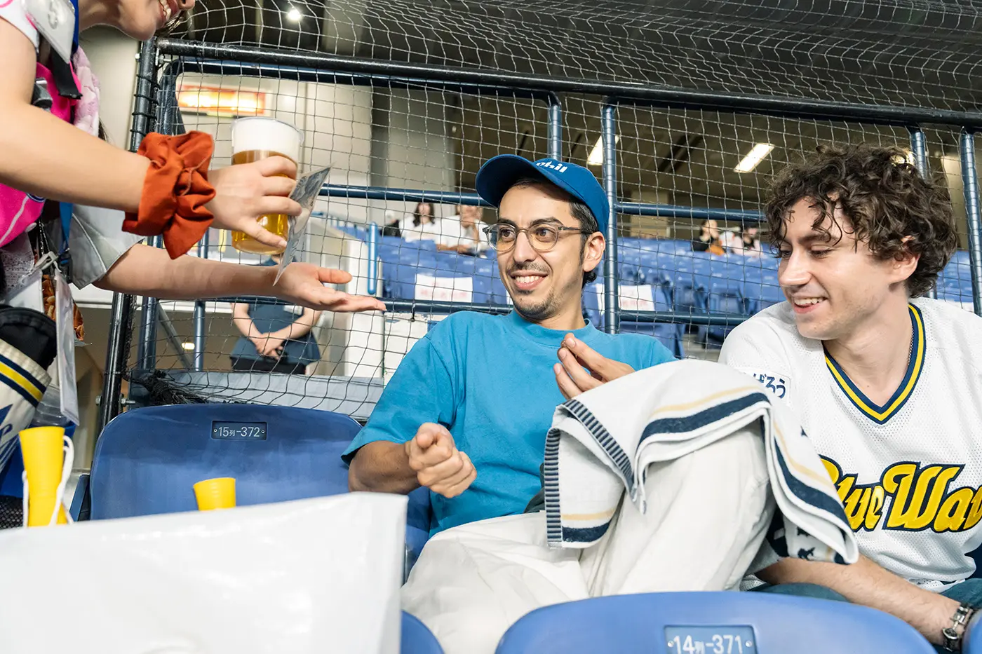 Enzo and Jason enjoying stadium food while watching the game