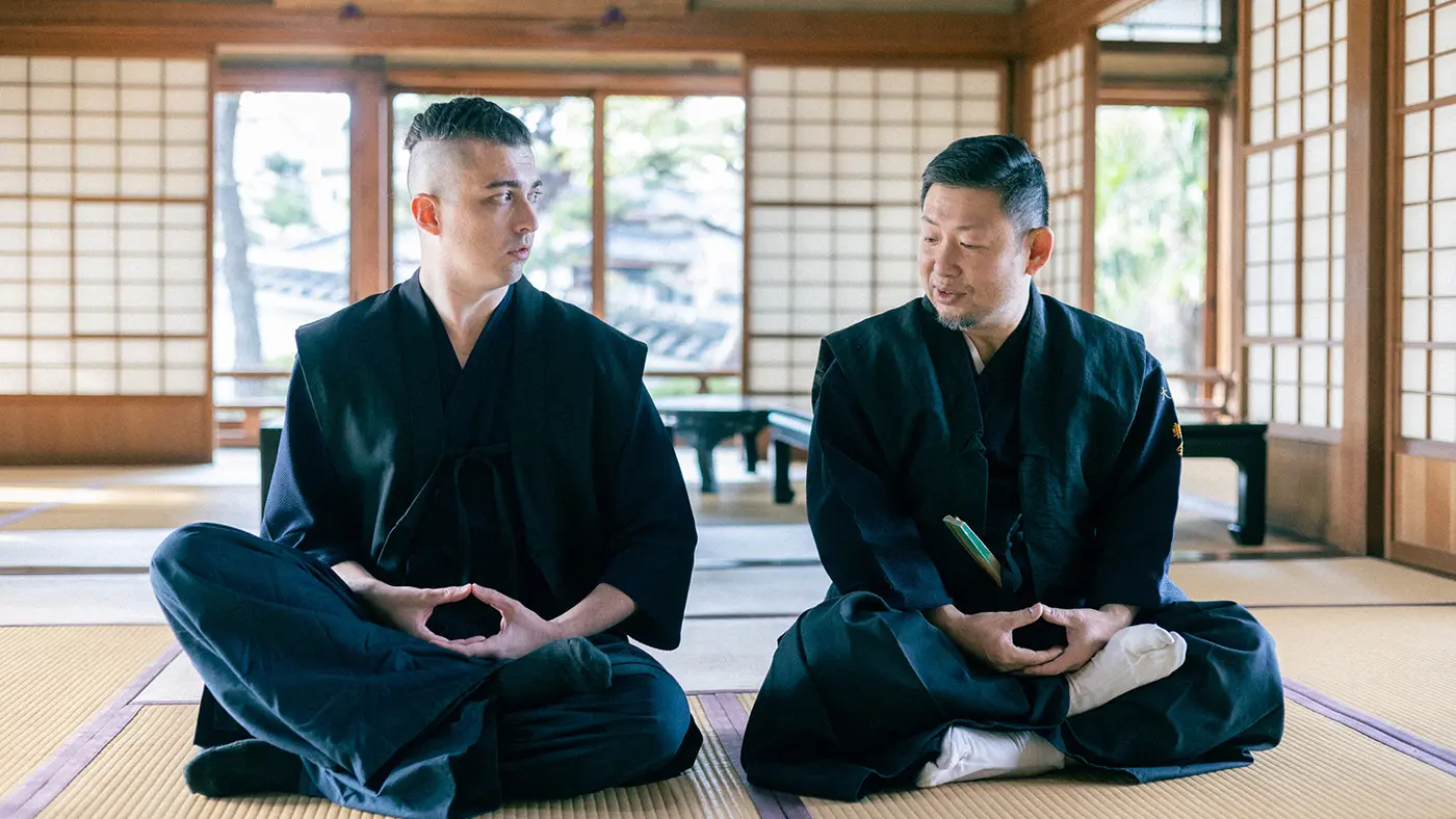 あぐらをかく吉塚さんとジェームズさん