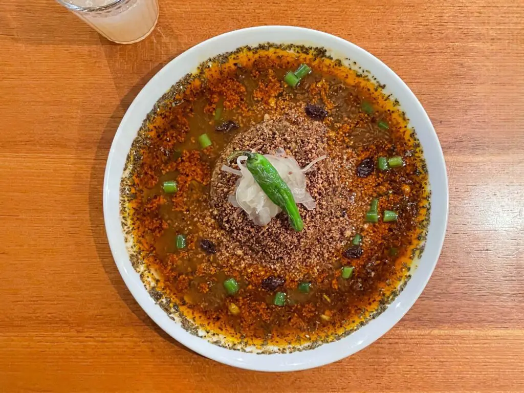 看板メニューは、左手に持ったししとうをかじりながら食べる「キーマカレー」。