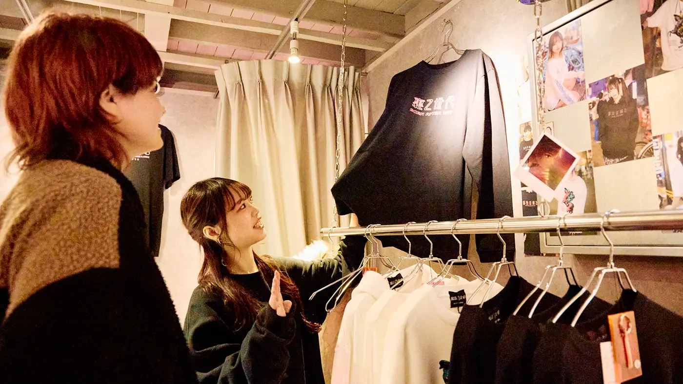 「裏Z世代」「都会は病む」など、ポップで毒のあるメッセージが描かれた服が印象的。