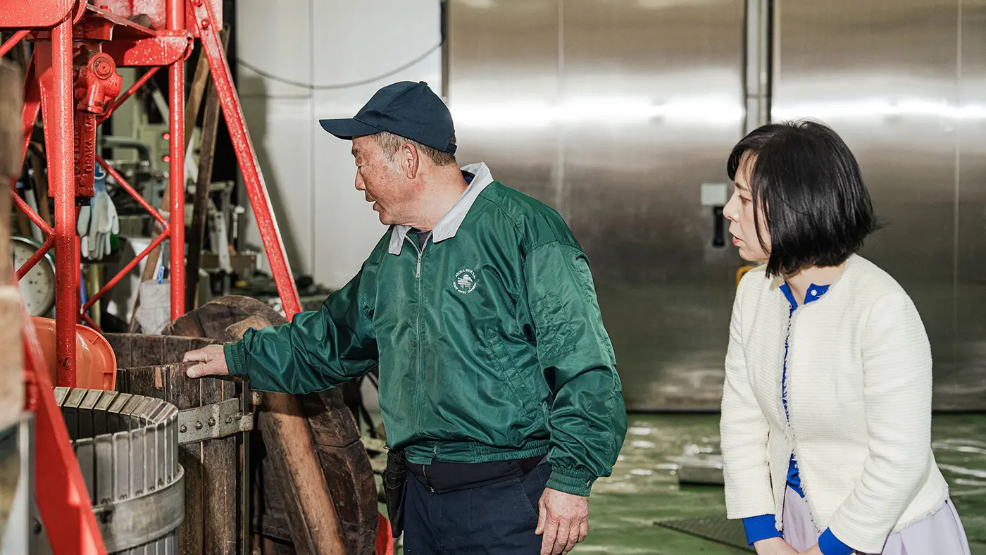 果実に圧力をかけて果汁を搾り出すワイン圧搾機（あっさくき）。木製の桶は、仲村さんが子どもの頃からあるそう