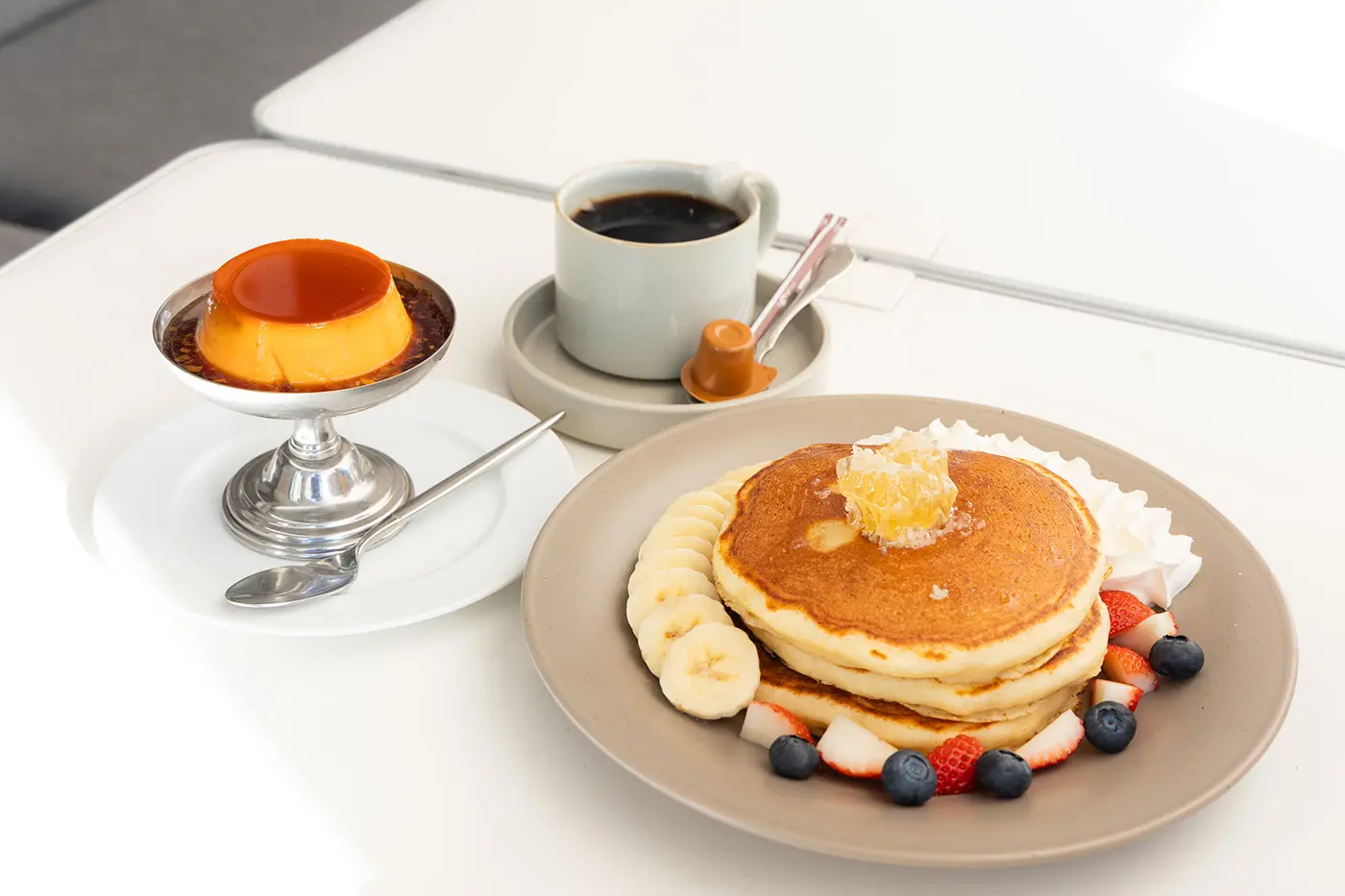 コームハニー＆フレッシュフルーツのパンケーキ1,500円、プレミアムプリン700円、タブレスブレンド600円（すべて税込）。