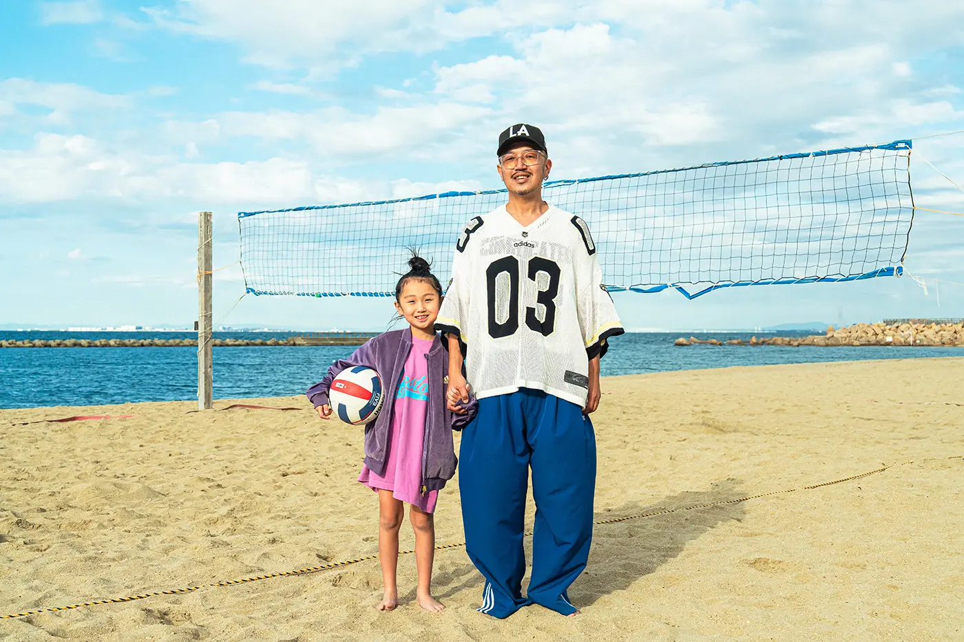 Parent and child standing on the beach