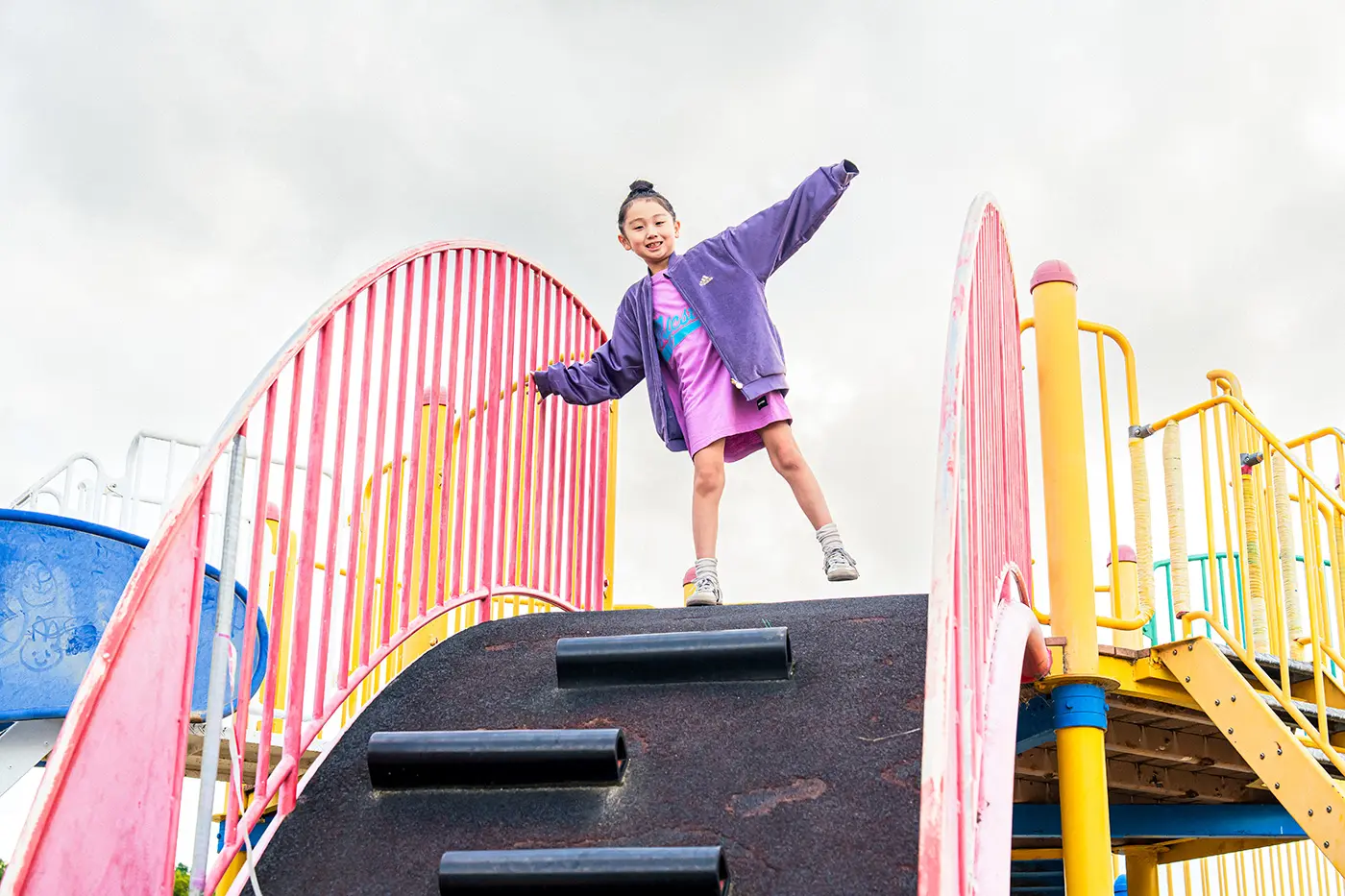 Girl climbing on playground equipment