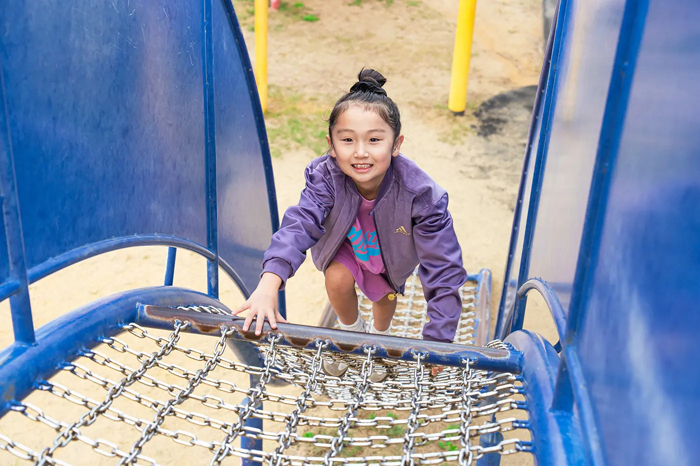 Girl climbing on playground equipment